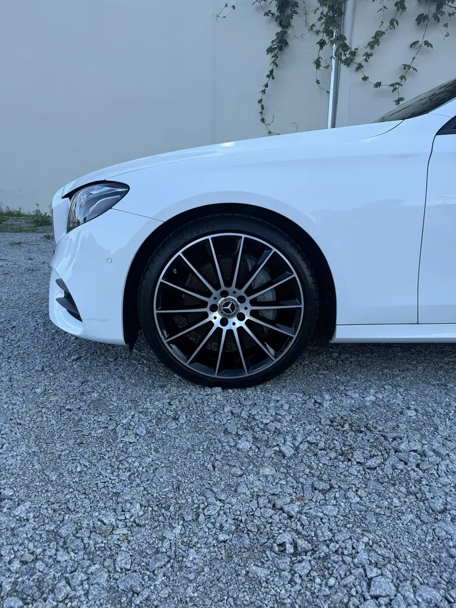 Przód białego Mercedesa, zbliżenie na koło i błotnik