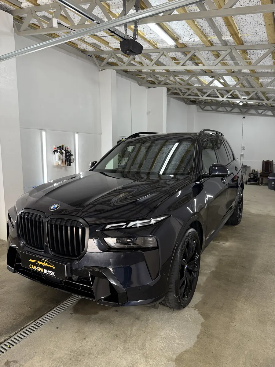 Czarne BMW X7 w hali, ujęcie od przodu pod kątem