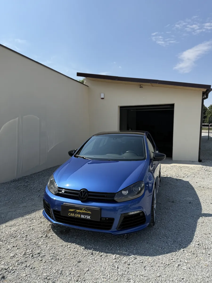 Niebieski Volkswagen Golf R przed halą, ujęcie od przodu