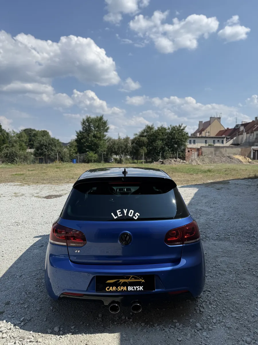 Tył niebieskiego Volkswagena Golfa R z plakietką Car-Spa Błysk